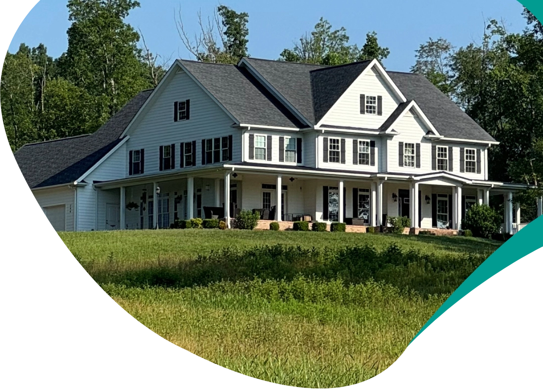 A large white house sitting on top of a green hill.