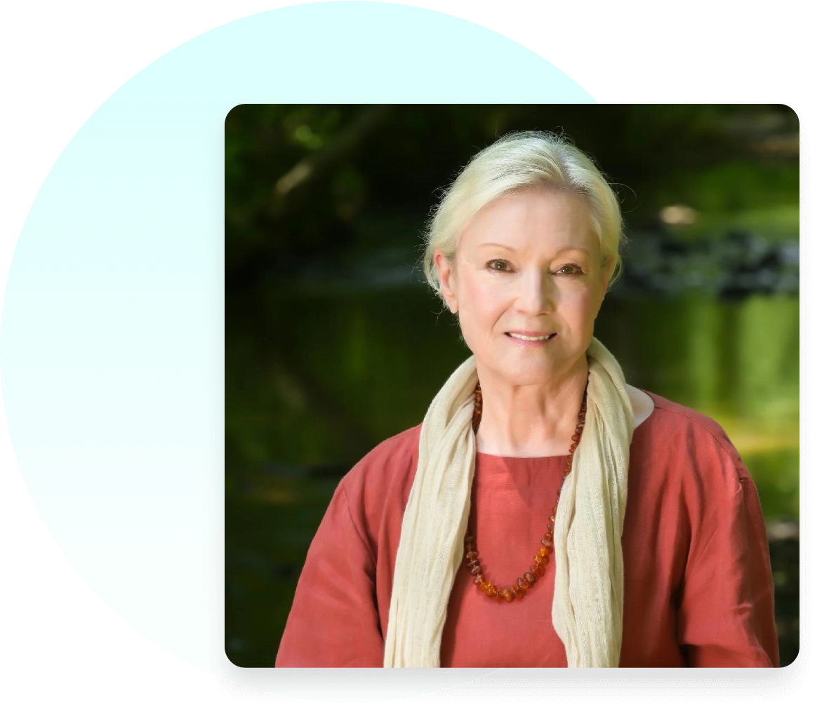 A woman with white hair wearing a red shirt and a scarf.